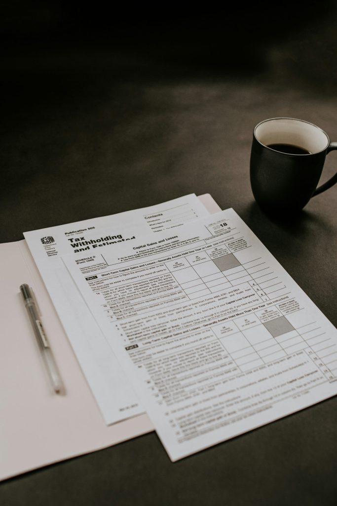 Tax forms on a desk with coffee.